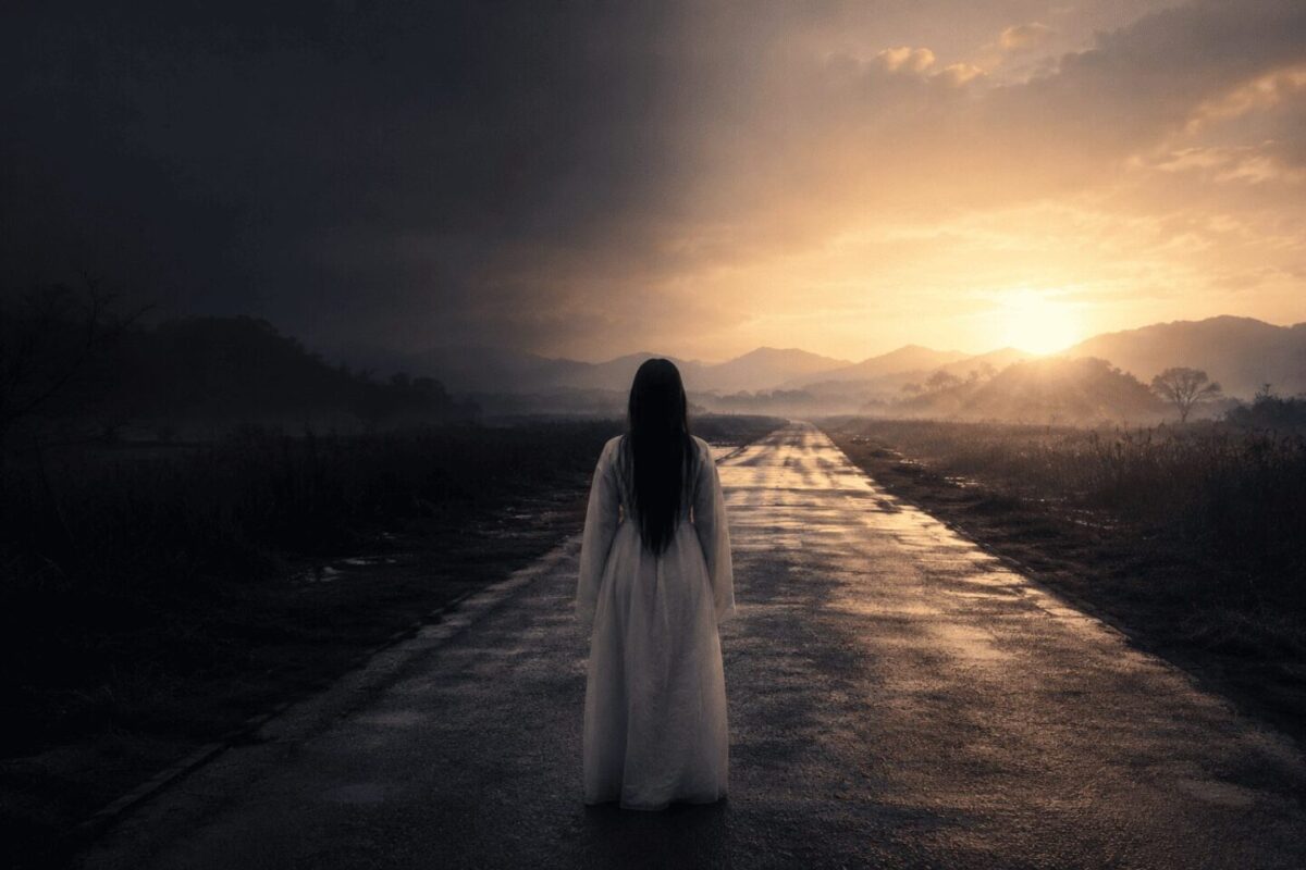 Woman in white hanbok facing dawn light on empty road, Korean gwishin han release