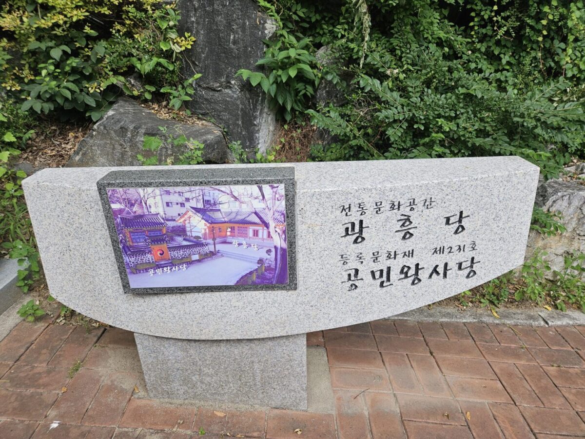 Stone marker with an inset photo panel reading "Gwangheungdang" and "King Gongmin's Shrine" at the entrance path in Mapo, Seoul