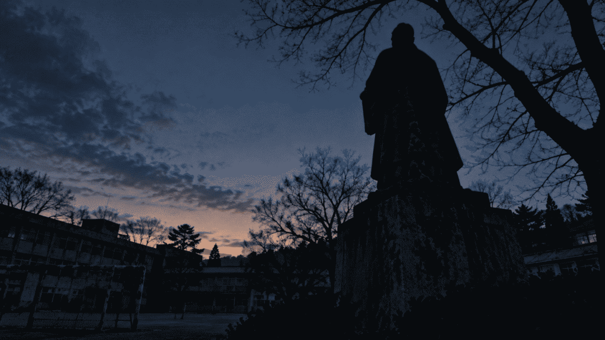 Silhouette of an old statue in a Korean schoolyard, linked to older Korean school ghost stories